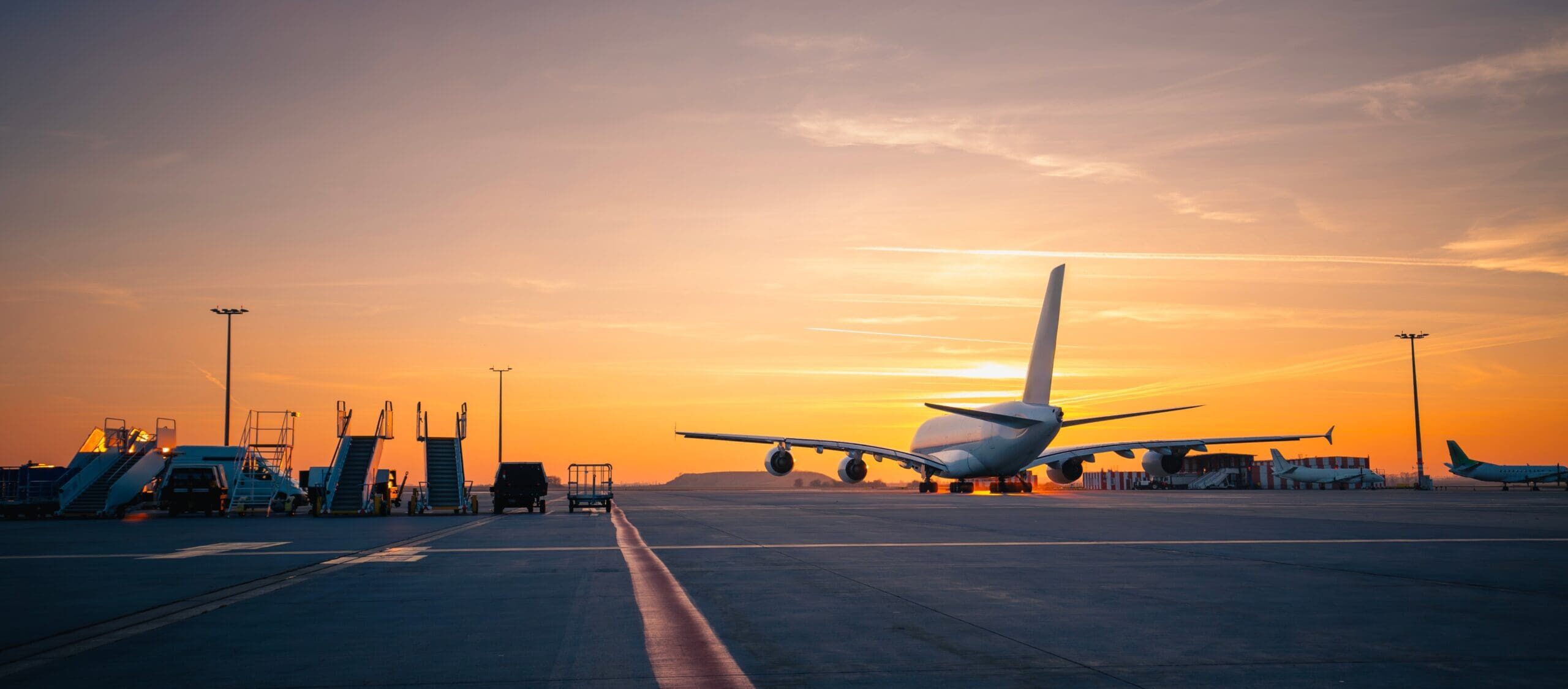 Traffic-At-Airport-At-Golden-Sunset-Wide-Shot-Of-Passenger-Plane